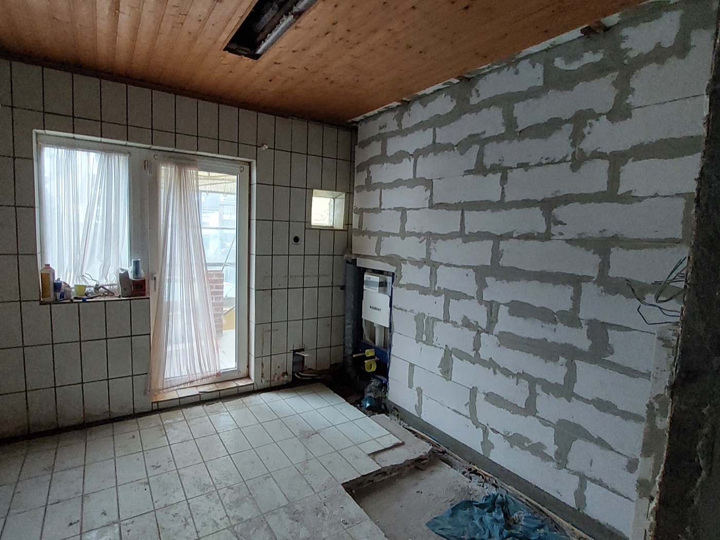 Altes Badezimmer in der Abriss-Phase mit freiliegenden Rohren
