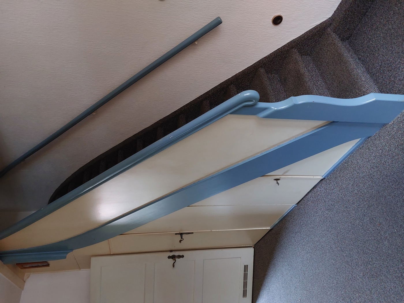 Alte blau lackierte Holztreppe mit verschiedenen Stauräumen unter den Stufen